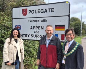 Alexa, Dr Samiullah and Mayor Stephen Shing stood in front of the twinning sign in Polegate