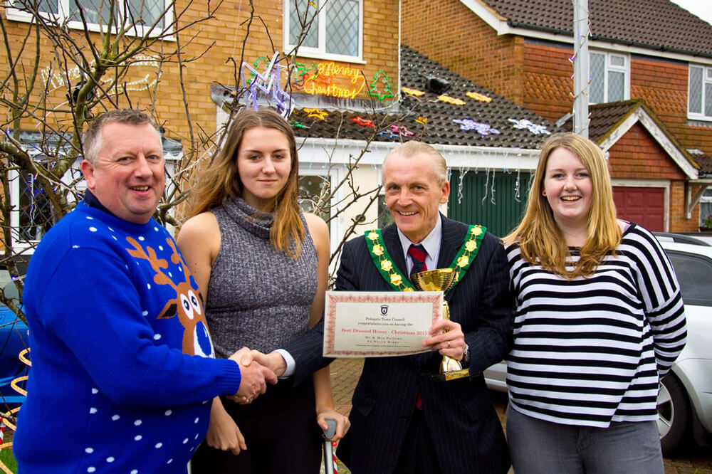 Mayor david watts presents the best dressed house award to the fellows family