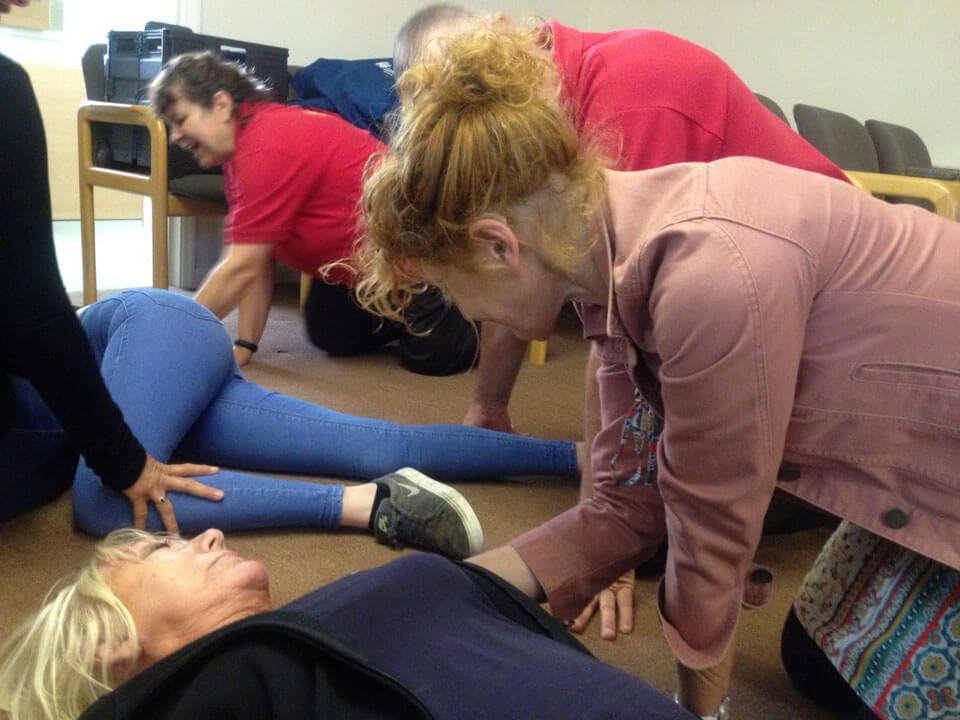 Mayor angela snell kneels next to a casualty at the heart start course