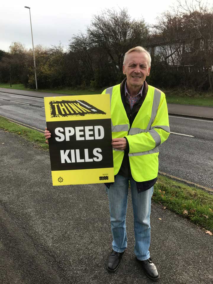 Mayor david watts displays a speed kills placard as part of a road safety initiative