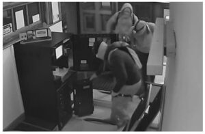 three suspects in a atm robbery pictured by cctv opening the atm in a bank